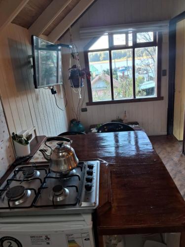 a kitchen with a stove and a counter top at Cabañas Queule in Queule