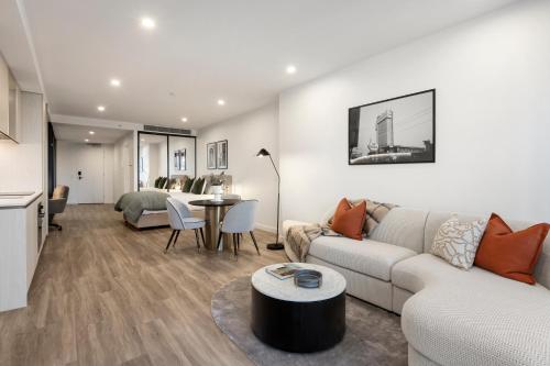 a living room with a couch and a table at Urban Rest City Road in Melbourne