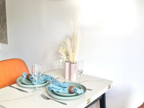 a table with two plates and wine glasses on it at Amber 1bdr-studio in Daisy Hill in Slacks Creek