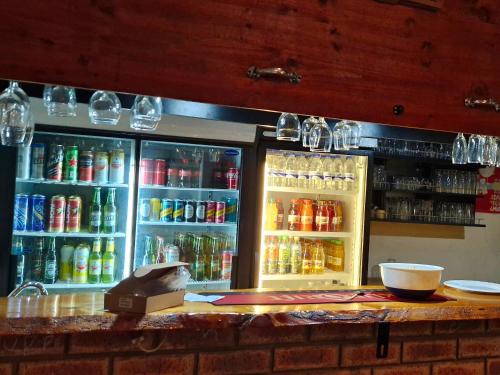 a refrigerator filled with lots of drinks on top of a bar at The Comfort Zone - Mthatha in Mthatha