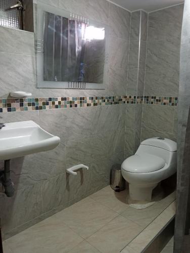 a bathroom with a toilet and a sink at apartamento esmeralda zipaquira in Zipaquirá