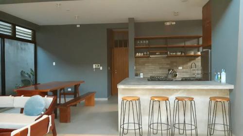 a kitchen with a counter and some chairs and a table at Casa completa, iluminada in Puerto Maldonado