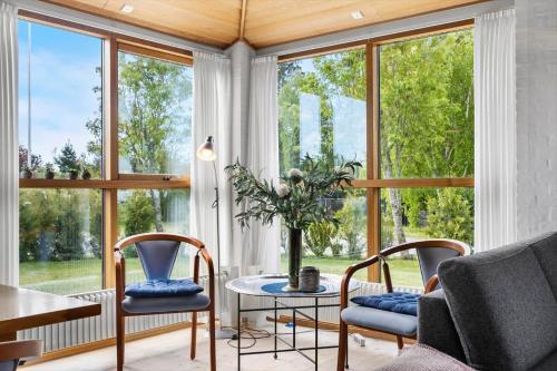 a living room with large windows and a table and chairs at TV1656-Skagen-Vandvaerksvej-16 in Skagen
