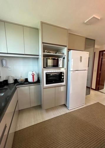 a kitchen with white cabinets and a white refrigerator at Apto completo cop 30 in Belém