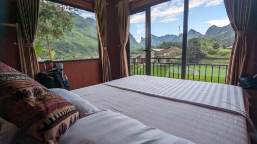 Yên MinhにあるDu Già Bungalowの大きな窓のある部屋のベッド