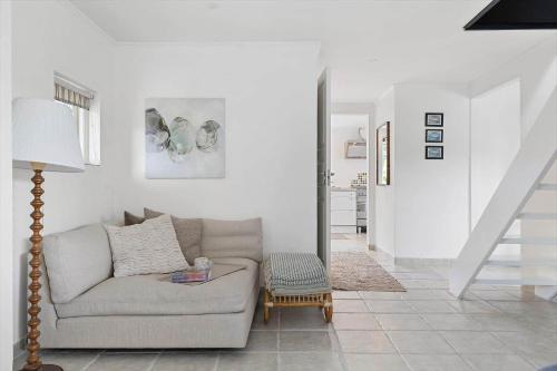 a living room with a couch and a staircase at TV1673-Bindslev-Noddevaenget-1 in Bindslev