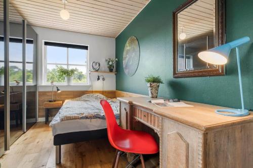 a bedroom with a bed and a desk with a red chair at K20042-Gorlev-Avej-23 in Gørlev