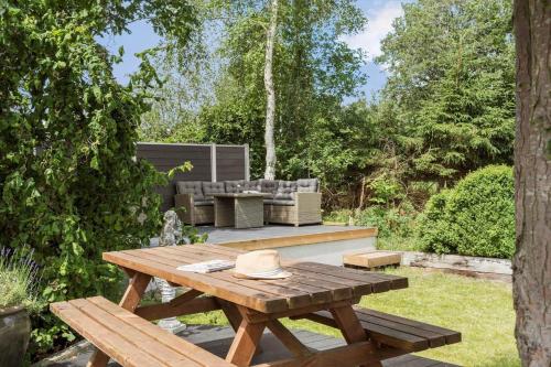 a wooden picnic table in a garden with a couch at K20042-Gorlev-Avej-23 in Gørlev
