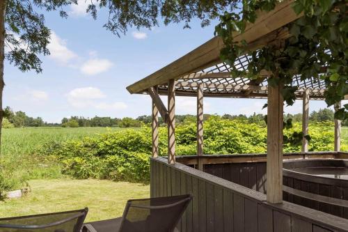 a deck with chairs and a pergola and a field at K20042-Gorlev-Avej-23 in Gørlev