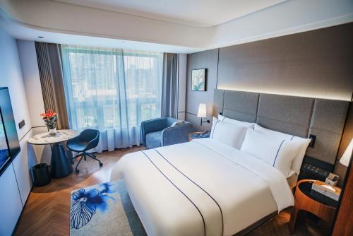 a hotel room with a large bed and a large window at Value Comfort Hotel Guangzhou in Guangzhou