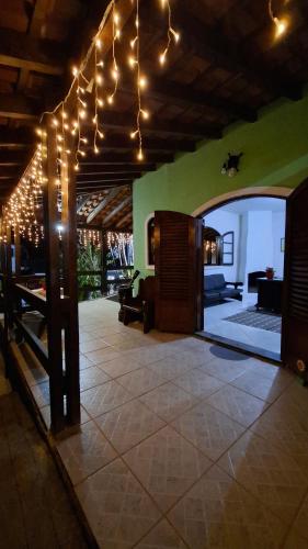 a living room with lights hanging from a ceiling at Pousada Luar de Penedo in Penedo