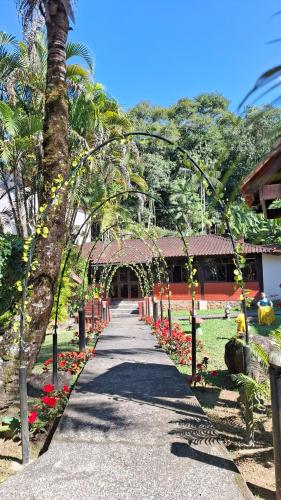 a walkway leading to a building with red flowers at Pousada Luar de Penedo in Penedo