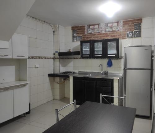 una cocina con fregadero y refrigerador en Casita entre árboles, casa de huéspedes céntrica y cómoda en San Fernando, Cali, en Cali