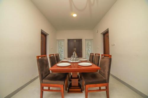 a dining room with a wooden table and chairs at Heavenly Hills 4 BHK Villa - 1 Bedroom in Kotagiri