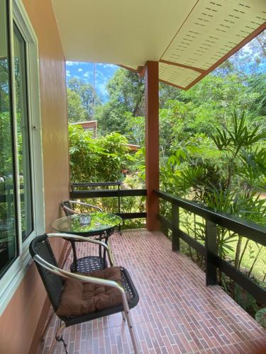a porch with a table and chairs on a balcony at Baan Longhaad in Ko Lanta