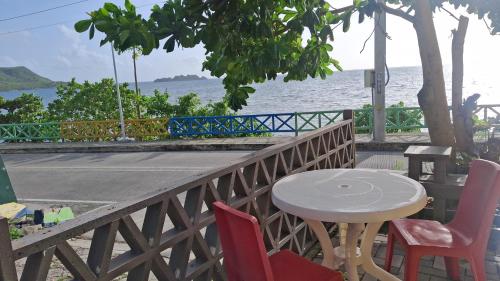 a table and chairs sitting next to the ocean at Apartamentos Bahia Rocky Point in Providencia
