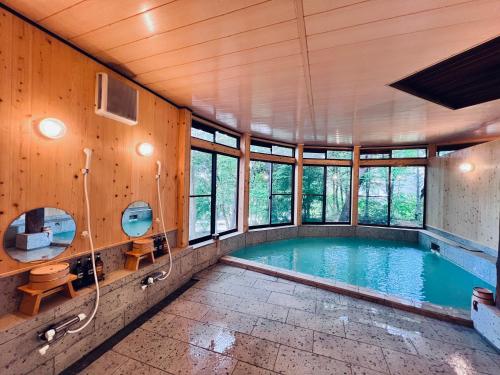 a swimming pool in a house with a bathroom at 草津白根 マウンテンビューロッジ in Kusatsu