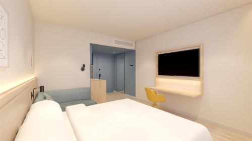 a hotel room with two beds and a television at Hampton By Hilton Caraguatatuba Serramar in Caraguatatuba