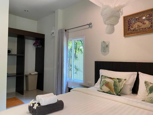 a bedroom with a large bed with a window at Baan Longhaad in Ko Lanta