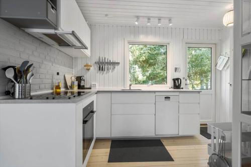 a white kitchen with a sink and a stove at K20079-Store-Fuglede-Fredskovens-Engvej-13 in Store Fuglede