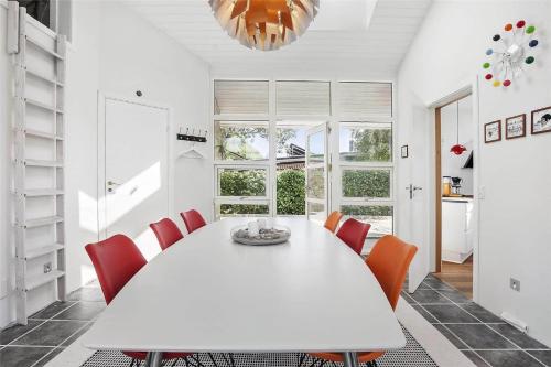 a white dining room with a white table and orange chairs at SL245-Rude-Fuglevaenget-20 in Rude