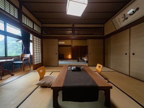 a room with a table and chairs and a bedroom at Okamotoya in Beppu