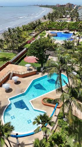 an aerial view of a resort pool and the beach at Cozy and Relaxing Oceanfront Apartment in Tucacas