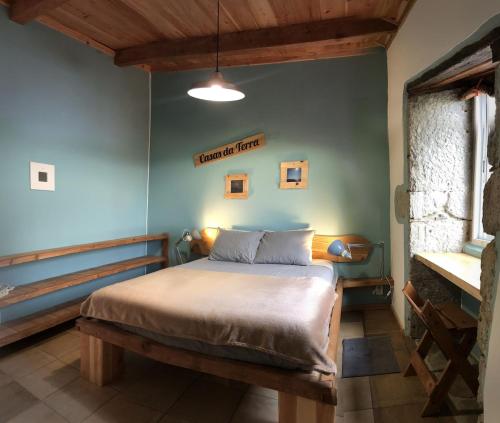 a bedroom with a bed and a blue wall at Casa Malagueta in Lajes das Flores