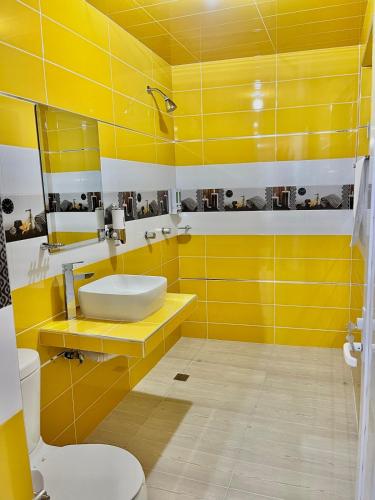 a yellow bathroom with a sink and a toilet at Mi bello Zacatlán-Suite Manzana Delicia in Zacatlán