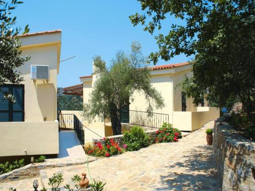 a house with a driveway and flowers in front of it at Stay for 2 at Aposperitis Drosia in Theodhóra