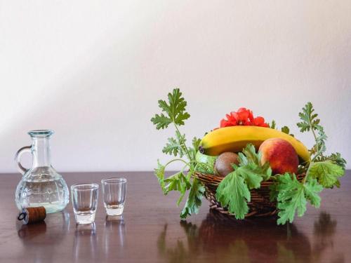 a basket of fruit on a table with water and glasses at Stay for 2 at Aposperitis Drosia in Theodhóra