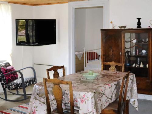a dining room with a table and chairs and a television at 6 person holiday home in KYRKHULT in Kyrkhult