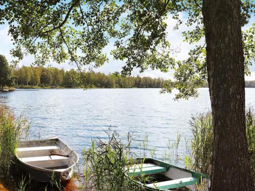 a boat sitting on the shore of a lake at 6 person holiday home in KYRKHULT in Kyrkhult