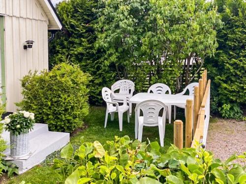 a white table and chairs in a garden at 6 person holiday home in MELLBYSTRAND in Mellbystrand