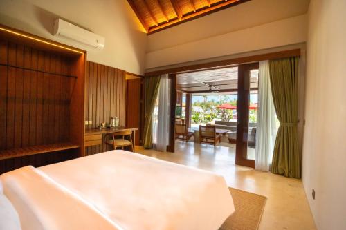 a bedroom with a bed and a living room at Amarta Beach Retreat by Nakula in Tabanan