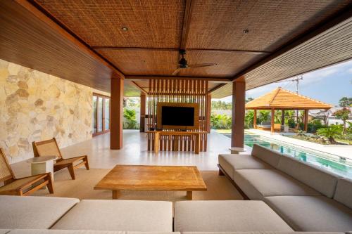 a living room with a couch and a table at Amarta Beach Retreat by Nakula in Tabanan