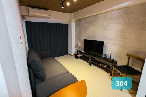 a living room with a couch and a flat screen tv at Nishi-Funabashi Residence in Funabashi