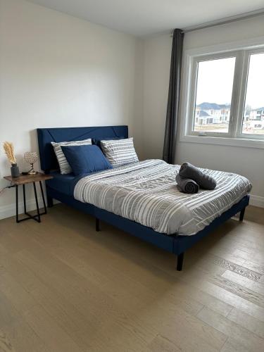 a blue bed in a bedroom with a window at Modern Luxurious Stay in Amherstburg