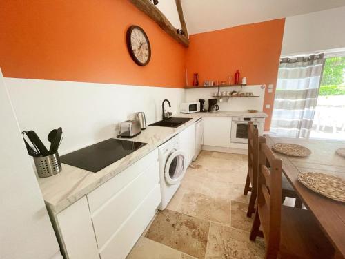 a kitchen with a washing machine and a table at Gîte paisible 2 chambres près de Tours et Amboise - FR-1-381-628 in Azay-sur-Cher