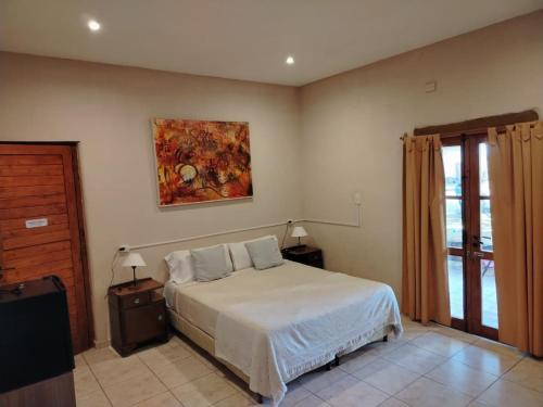 a bedroom with a bed and a painting on the wall at Posada Cavieres Wine Farm in Maipú