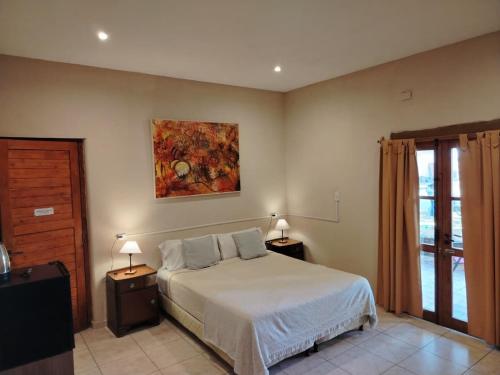 a bedroom with a bed and two night tables with lamps at Posada Cavieres Wine Farm in Maipú