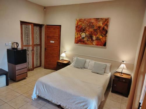 a bedroom with a bed and a painting on the wall at Posada Cavieres Wine Farm in Maipú