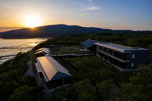 an aerial view of a building with the sunset in the background at 山人 Oga in Oga