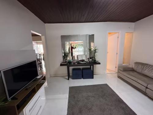 a living room with a couch and a television at CASA COP 30 - Conjunto Marex - A poucos metros do Hangar e do Aeroporto de Belém in Belém