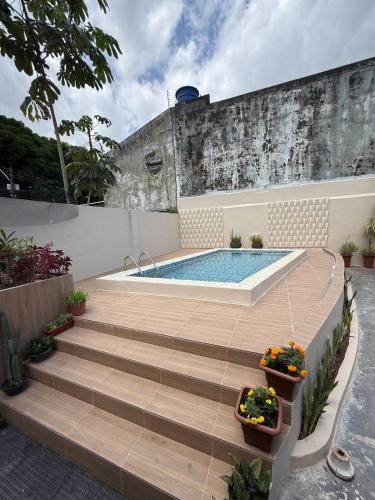 a swimming pool with stairs leading up to a house at CASA COP 30 - Conjunto Marex - A poucos metros do Hangar e do Aeroporto de Belém in Belém