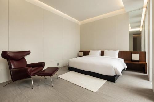 a bedroom with a white bed and a chair at Uniisland The Spaville in Incheon