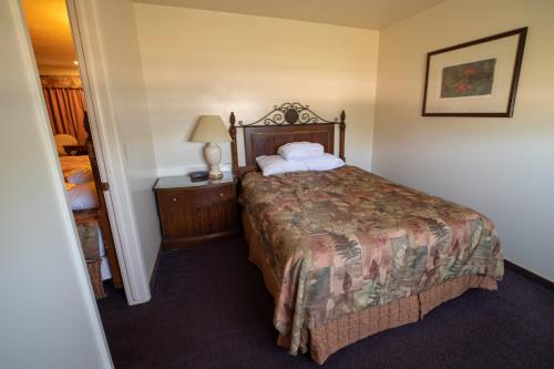 a hotel room with a large bed and a lamp at Clover Creek Inn in Montpelier
