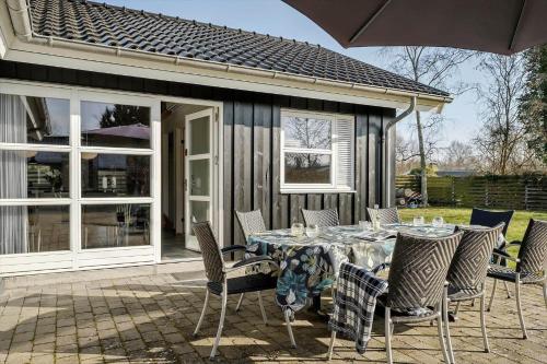 a patio with a table with chairs and an umbrella at K20083-Gorlev-Juliusvej-1 in Gørlev