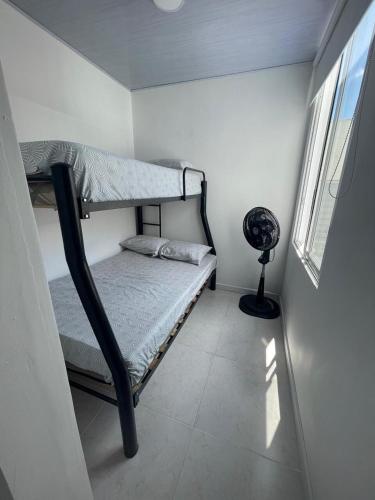 a small bedroom with a bunk bed and a window at Disfruta y descansa en esta casa con Aire acondicionado in Ricaurte