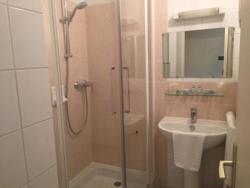 a bathroom with a shower and a sink at Location chambres Hôtel Joly in Dun-le-Palestel